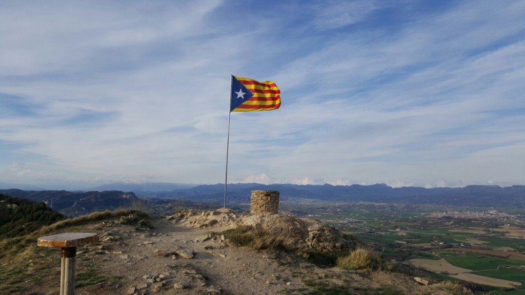 Estelada i taula rodona al cim amb les muntanyes de Núria i l'Olla al fons
