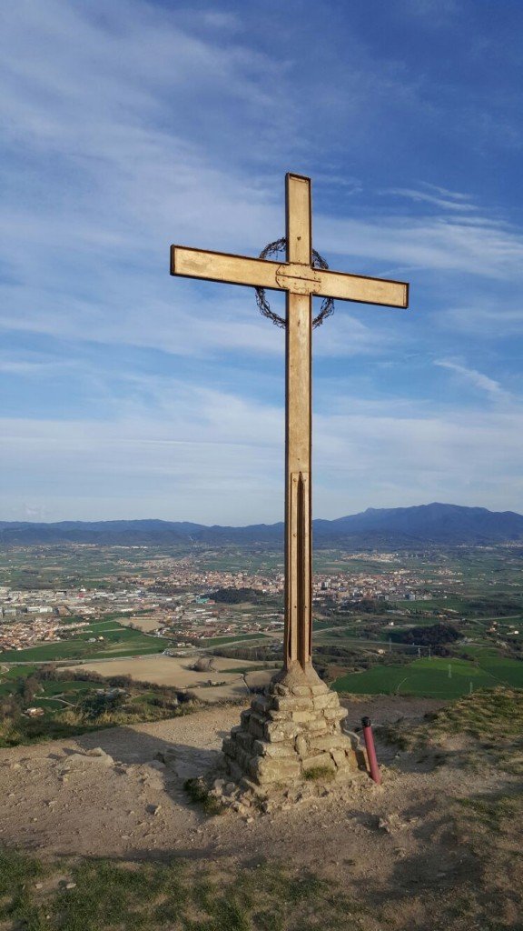 I com no la Creu amb Vic (La Ciutat dels Sants) de fons